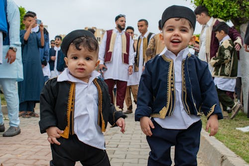Cute Little Toddlers Wearing Traditional Clothing while Smiling at the Camera