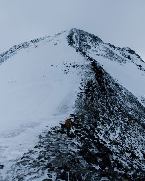 Free A solitary climber ascends a snowy mountain in Dombay, Russia, capturing the essence of winter adventure. Stock Photo