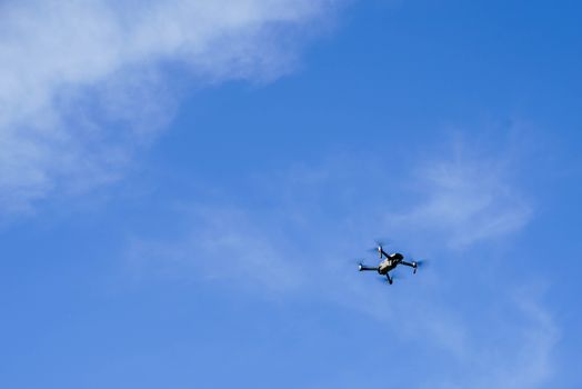 A drone captured flying high in the clear blue sky, showcasing modern technology in action.