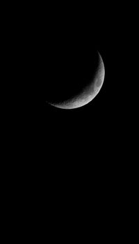 A monochrome crescent moon set against a deep black night sky. Ideal for astronomy lovers.
