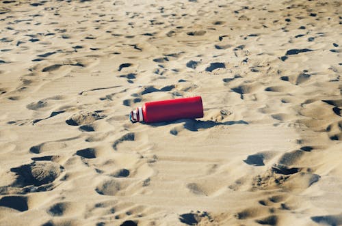 Free Red and Silver Can on Sand Stock Photo