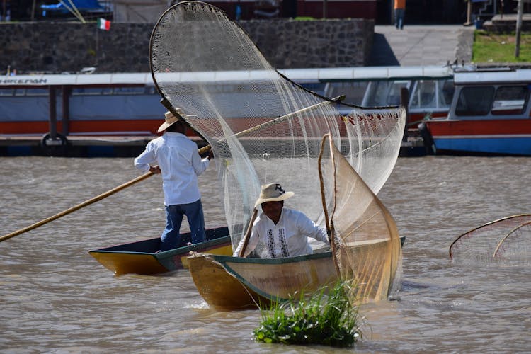 Men Wearing Traditional Clothing Sailing In Fishing Boats With Nets 