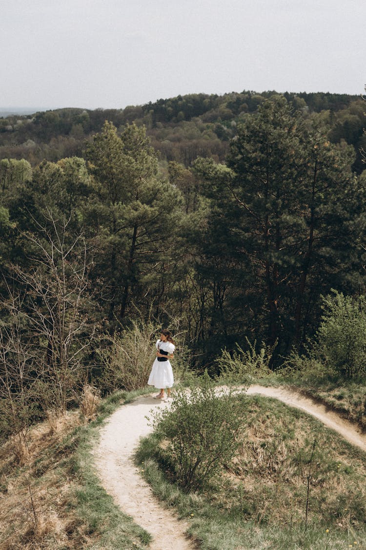 Woman On Footpath With Forest Behind