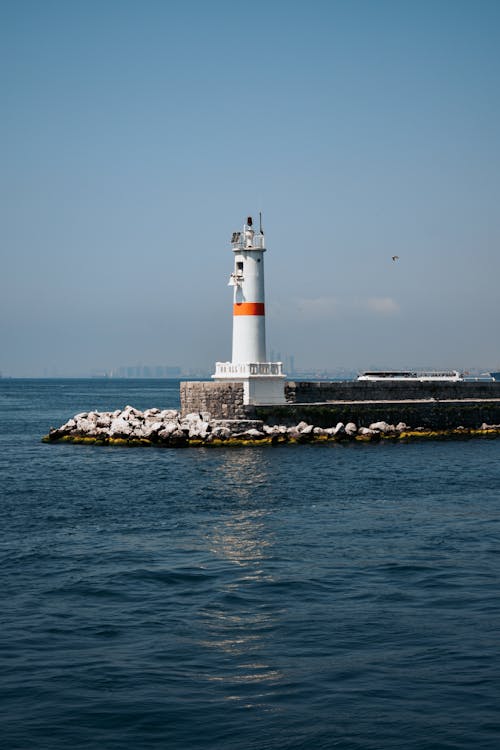 deniz feneri, deniz kenarı, dikey atış içeren Ücretsiz stok fotoğraf