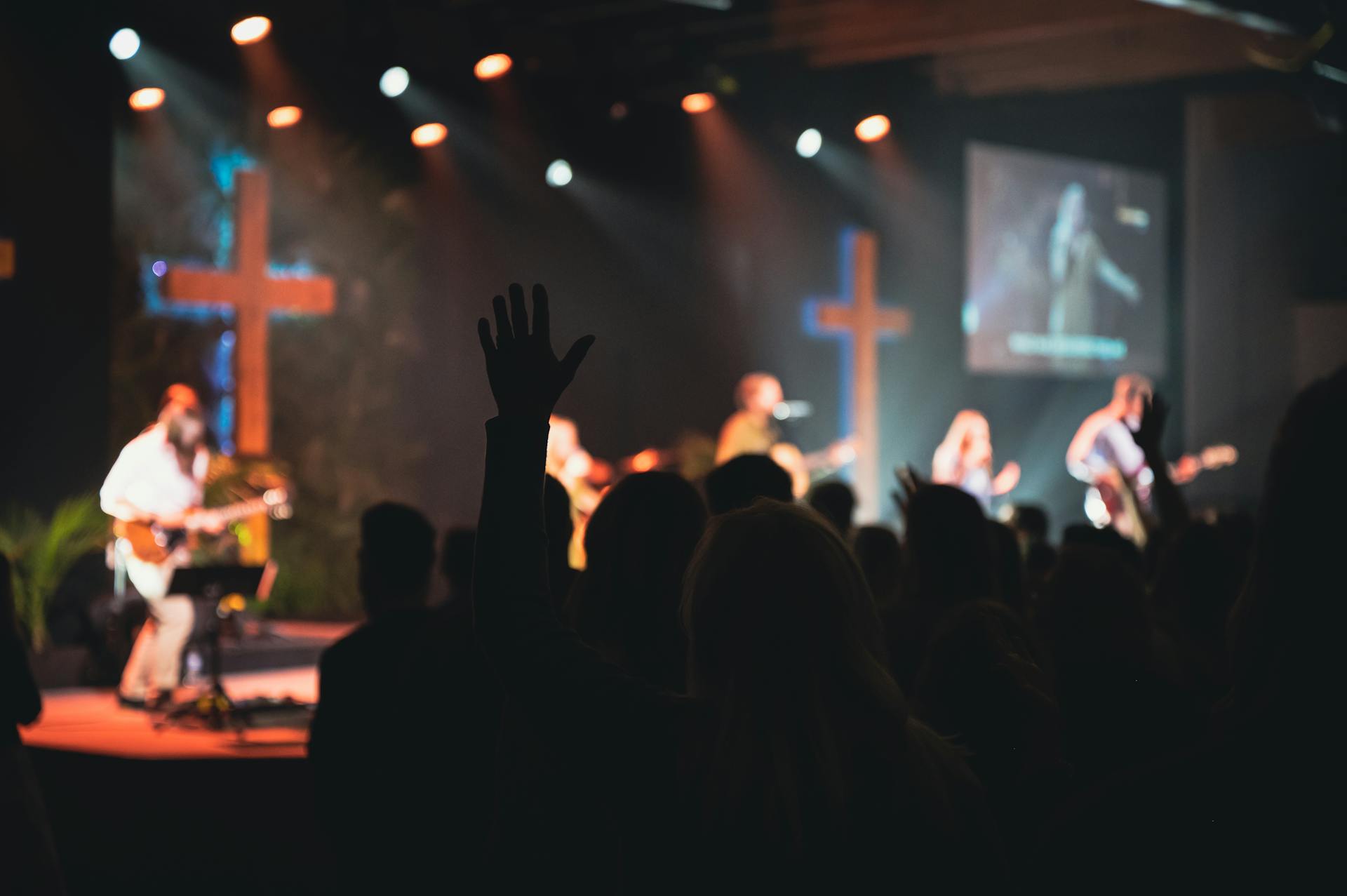 A vibrant church music band performing on stage with guitars and singers.