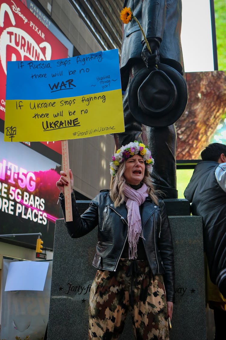 A Protester Wearing Flower Crown Holding A Banner