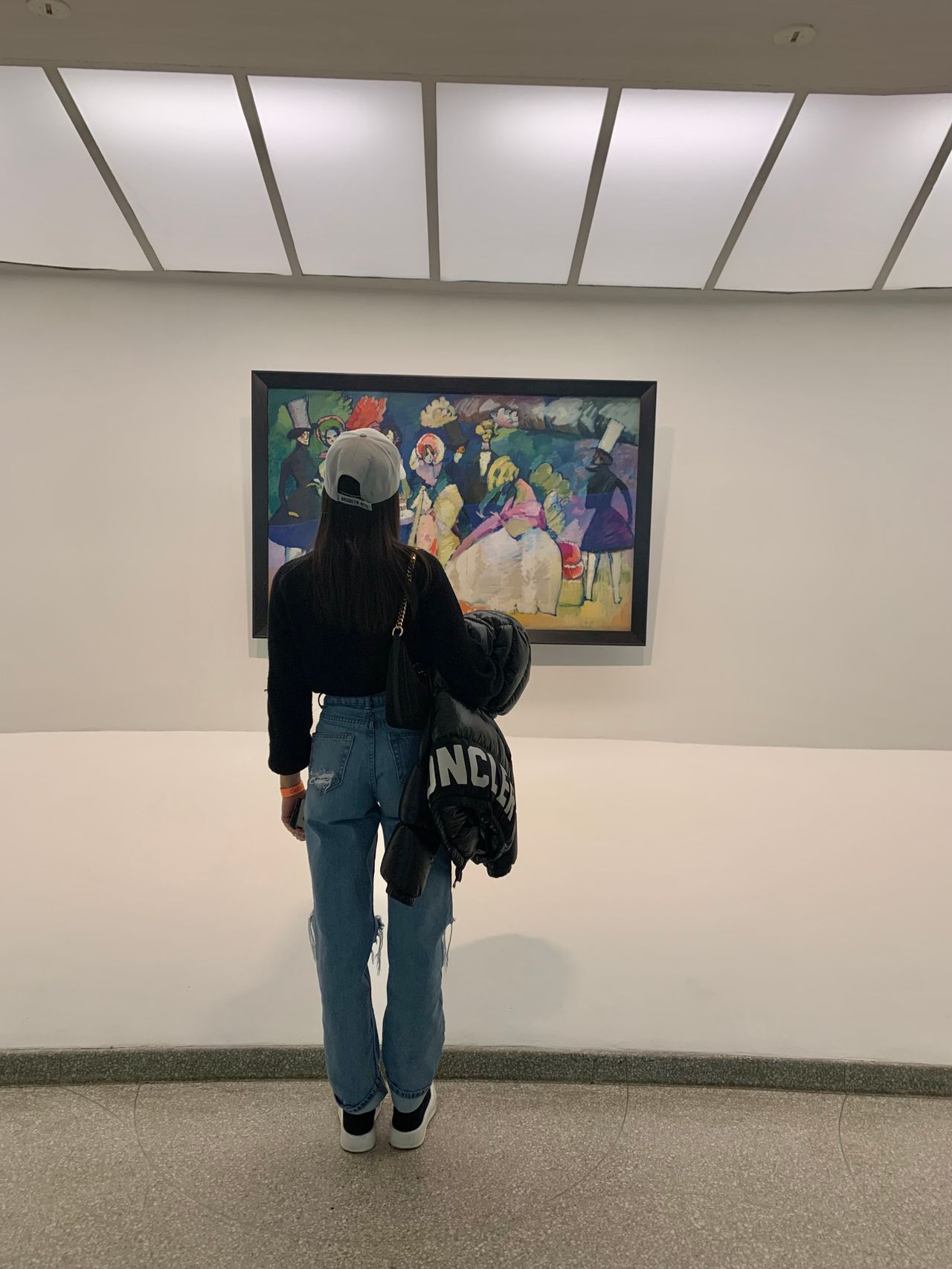 A Woman Admiring a Painting at an art gallery