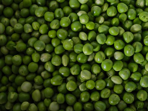 Free A vibrant close-up of fresh green peas, showcasing their natural texture and vivid color. Stock Photo