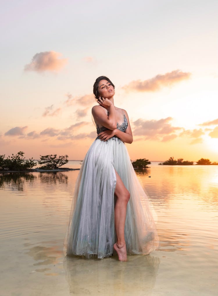 Woman In Dress Posing On Beach At Sunset