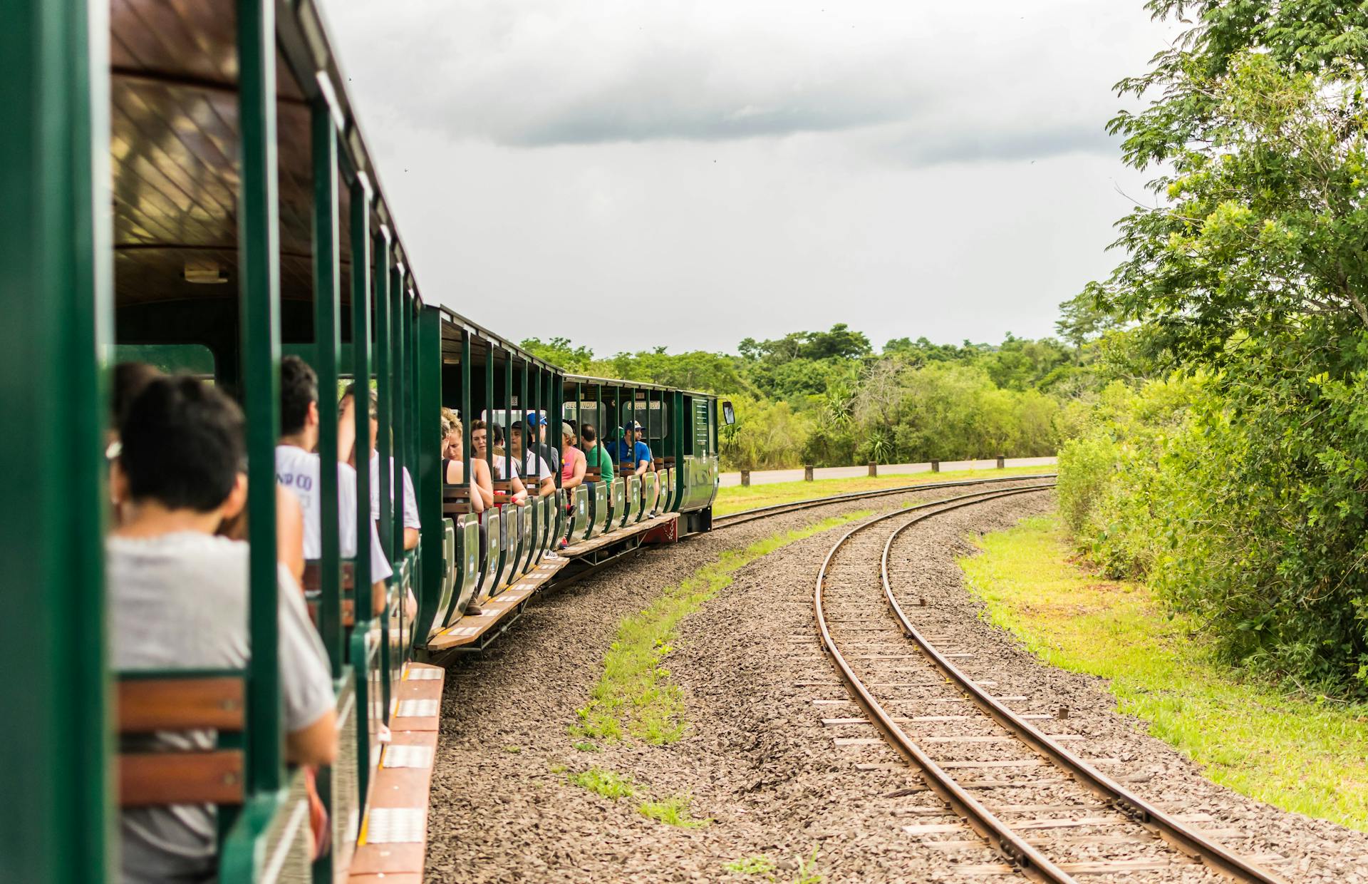 Tourists enjoy a scenic train ride through the lush landscape of Iguazú National Park, Argentina.