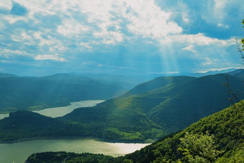 Aerial Photography of Green Mountains under the Cloudy Sky