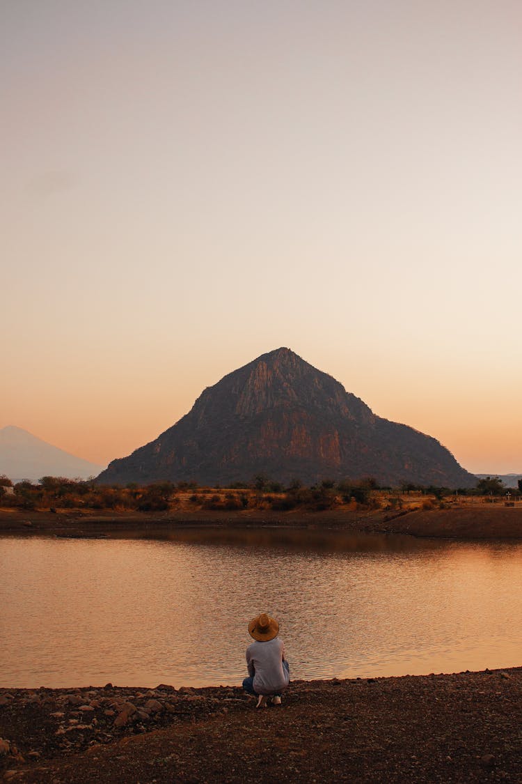 Man Looking At Lonely Mountain And River In Light Of Rising Sun