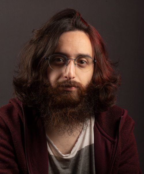 Free Close-up portrait of a young bearded man wearing glasses, neutral expression. Stock Photo