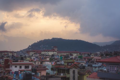 Free Aerial view of urban Kathmandu with a dramatic sunset sky and mountainous backdrop. Stock Photo