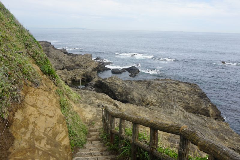 Serene seaside path with rocky shore and ocean waves, ideal for coastal explorations.