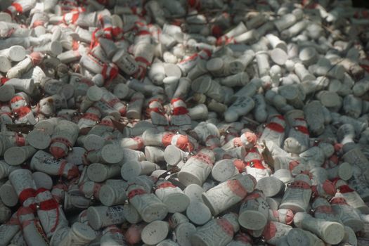 A multitude of painted figurines with red decorations densely covering the ground outdoors.