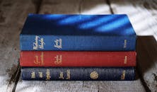 明亮的灯光下，勃朗特、狄更斯和奥斯汀的经典作品堆叠在木制表面上