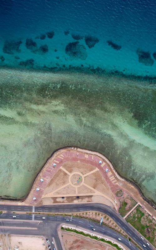 Free Stunning aerial view of the Umluj coastline, Tabuk Province, showcasing clear waters and coastal roads. Stock Photo