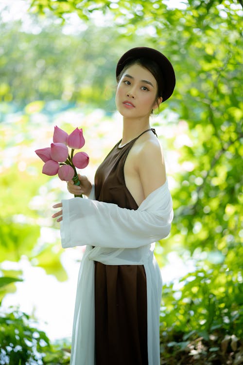 Woman in Dress Holding Flowers