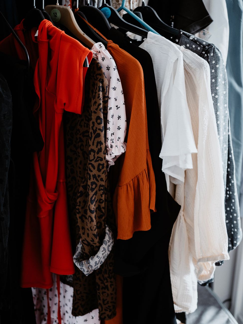 A diverse collection of colorful clothing on hangers showcasing a range of fashion styles.
