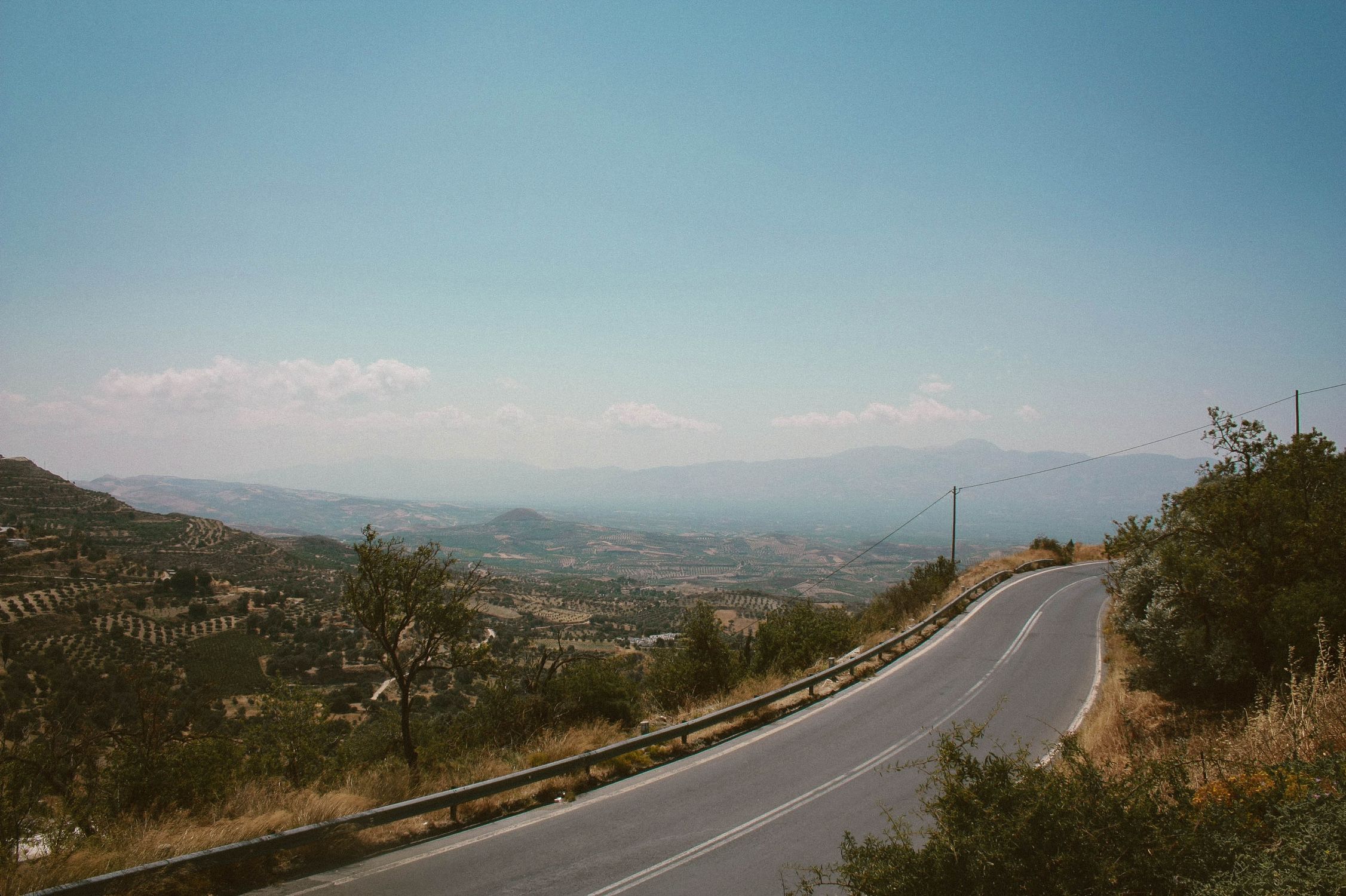 Breathtaking view of a winding road through Rethymno's landscape with clear blue skies.