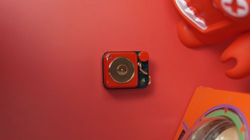 Free A vibrant toy radio on a red surface, evoking nostalgia with its vintage design. Stock Photo