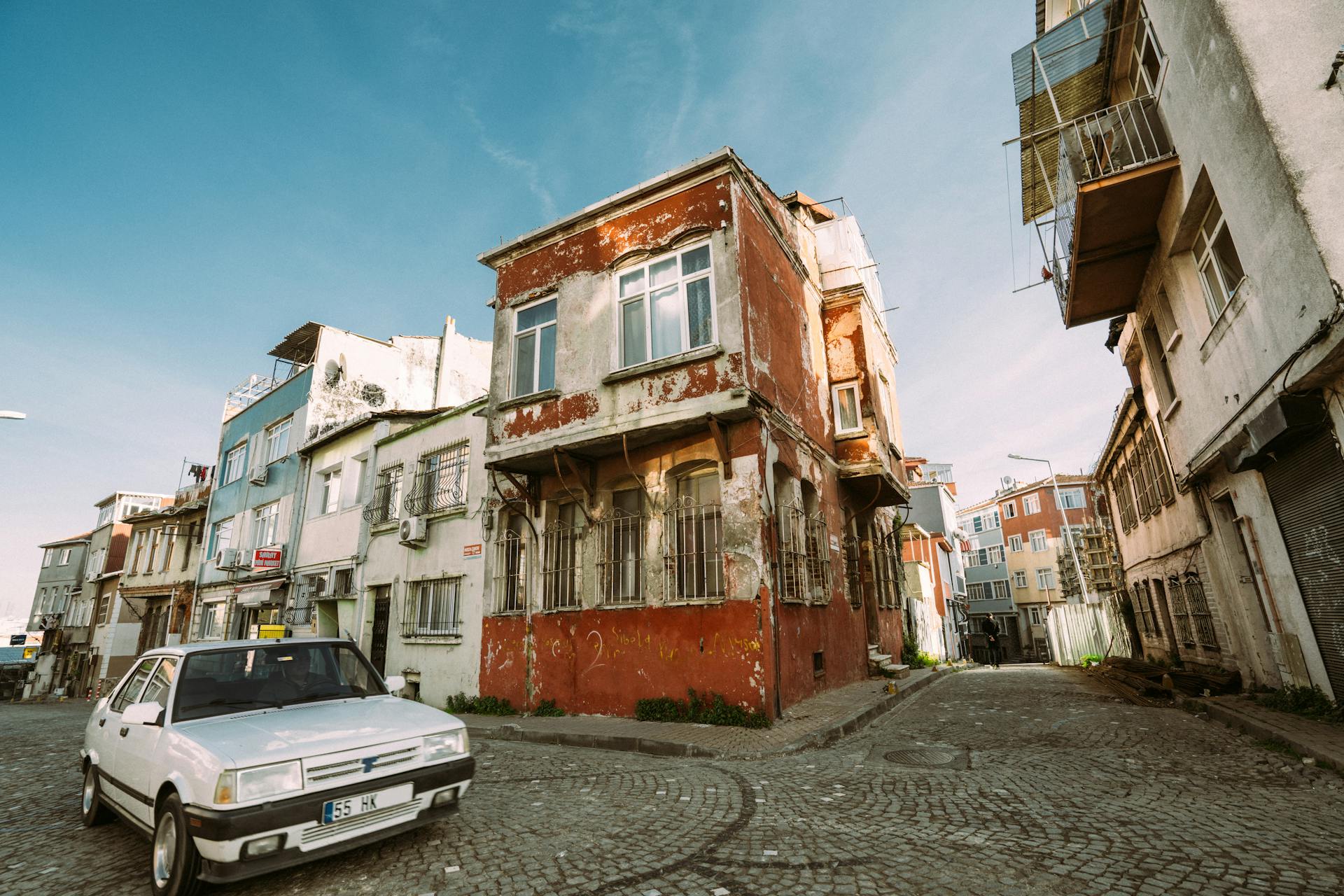 Abandoned buildings on a cobblestone street corner, showcasing urban decay.