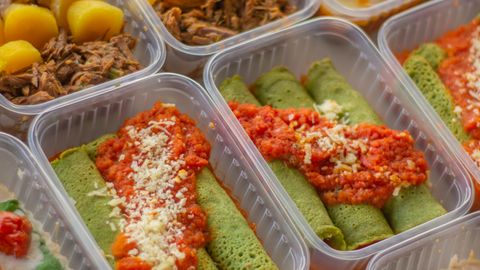 An assortment of healthy, colorful meal prep boxes featuring vegetables, grains, and proteins.