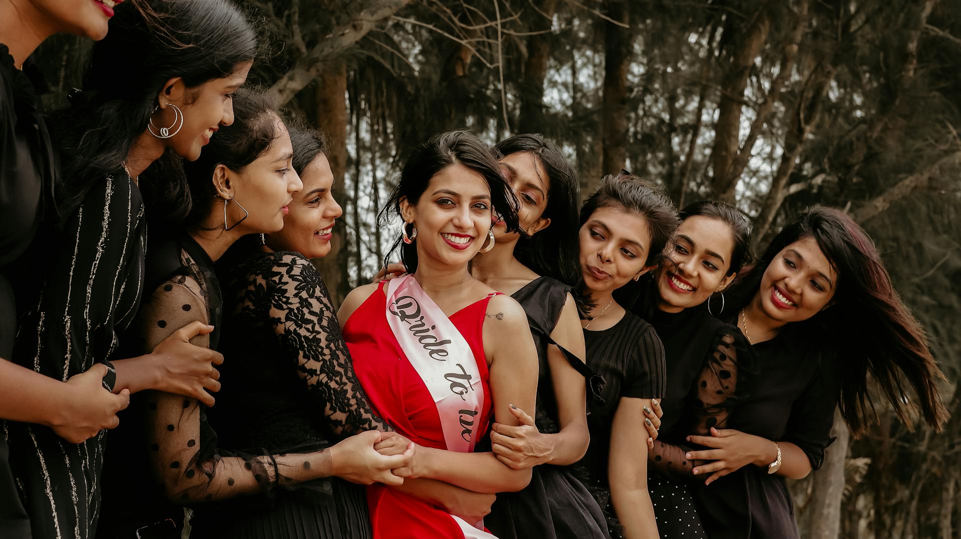 Smiling women enjoying a lively bachelorette party outdoors, showcasing friendship and happiness.