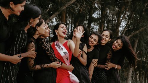 Free A group of women joyously celebrating outdoors with the bride-to-be wearing a sash. Stock Photo