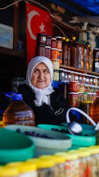 Elderly woman selling traditional products at a market stall in Bursa, Turkey.