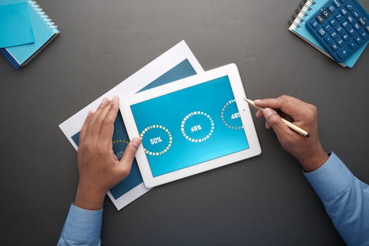 A professional reviewing statistical data on a digital tablet. Top view of business analysis.