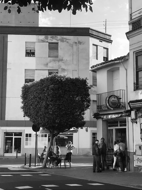 Black and white street scene in Castellón de la Plana, Spain featuring people and urban architecture.