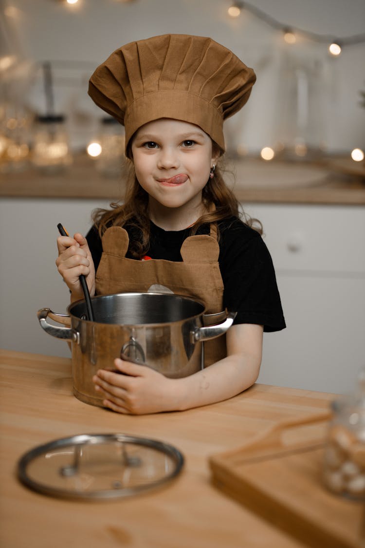 Little Girl Dressed As A Chef Cooking