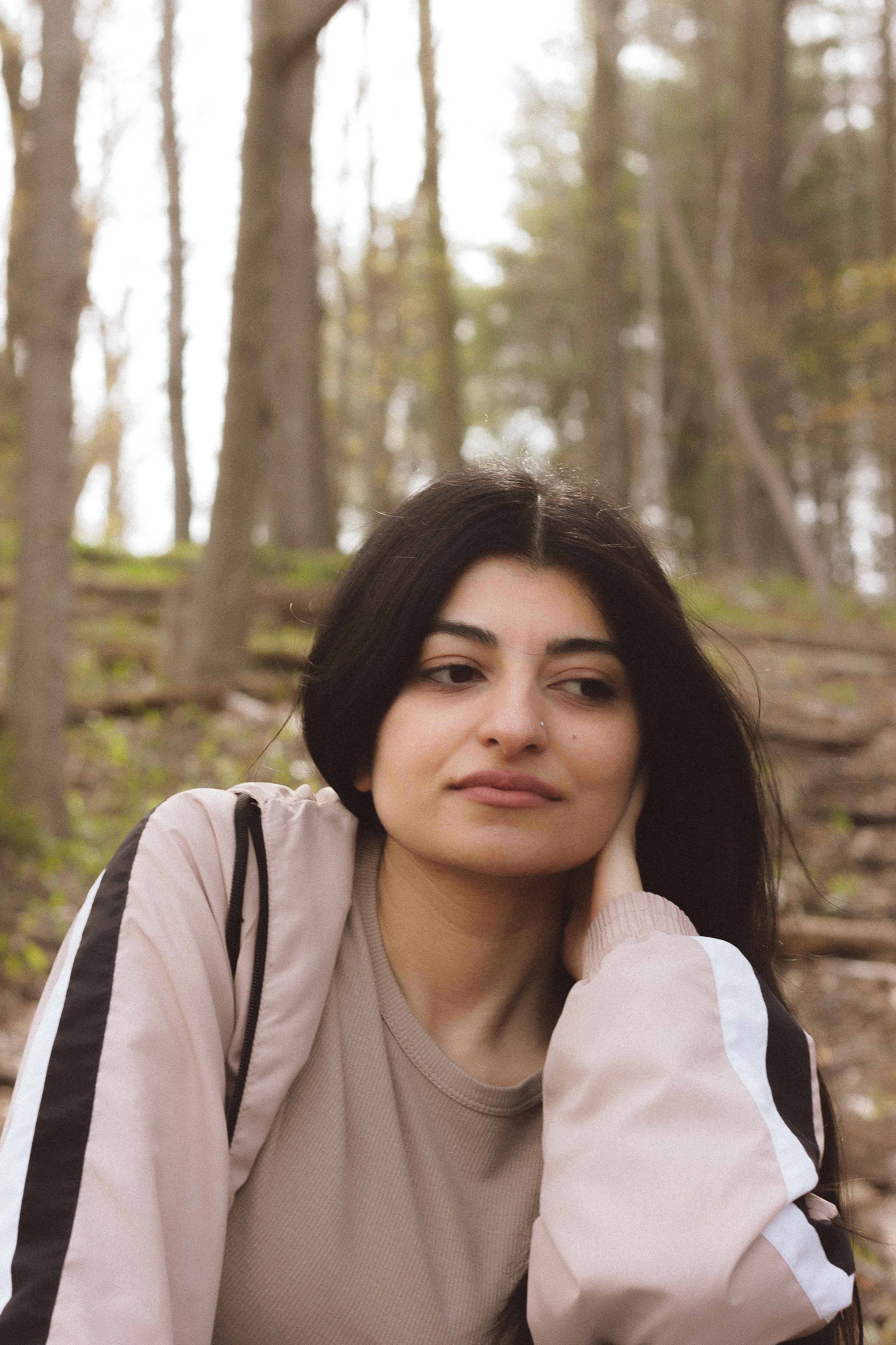Woman relaxing outdoors in a serene forest environment.