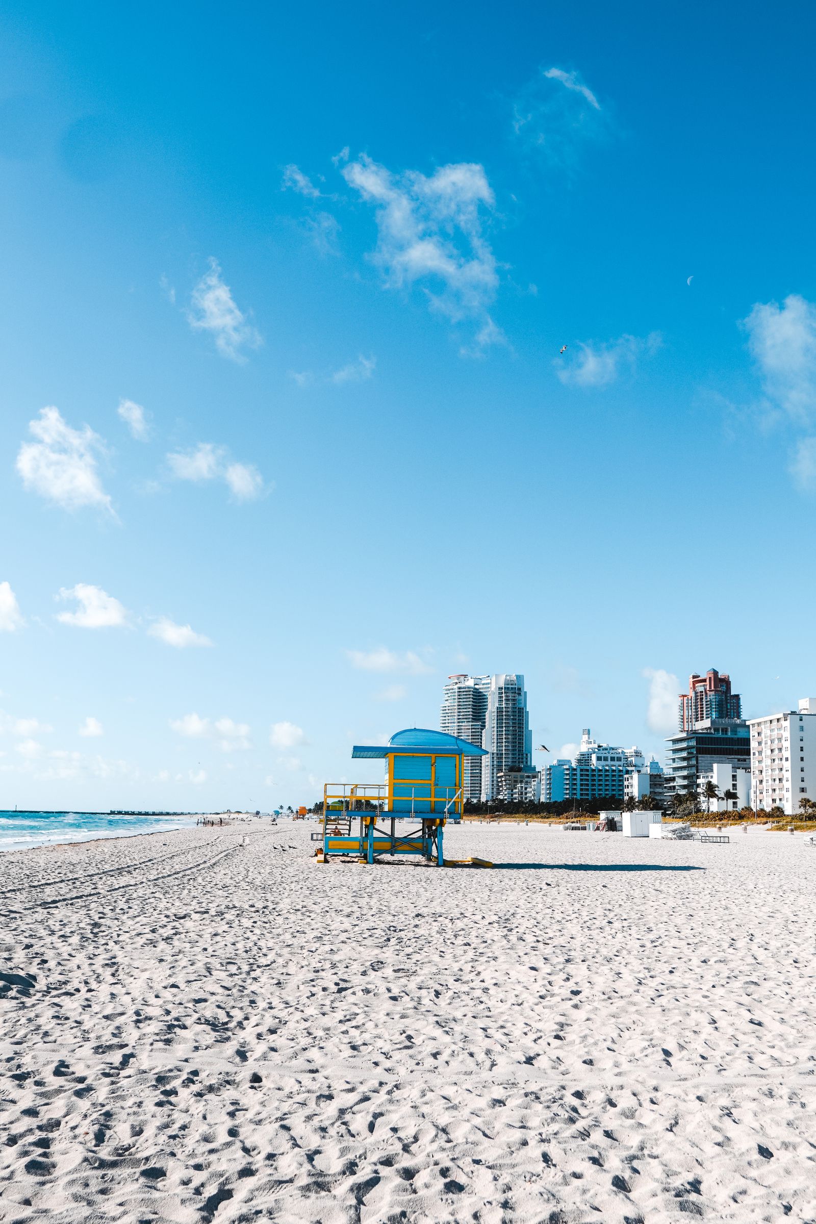 Beach under blue sky with a colorful lifeguard tower