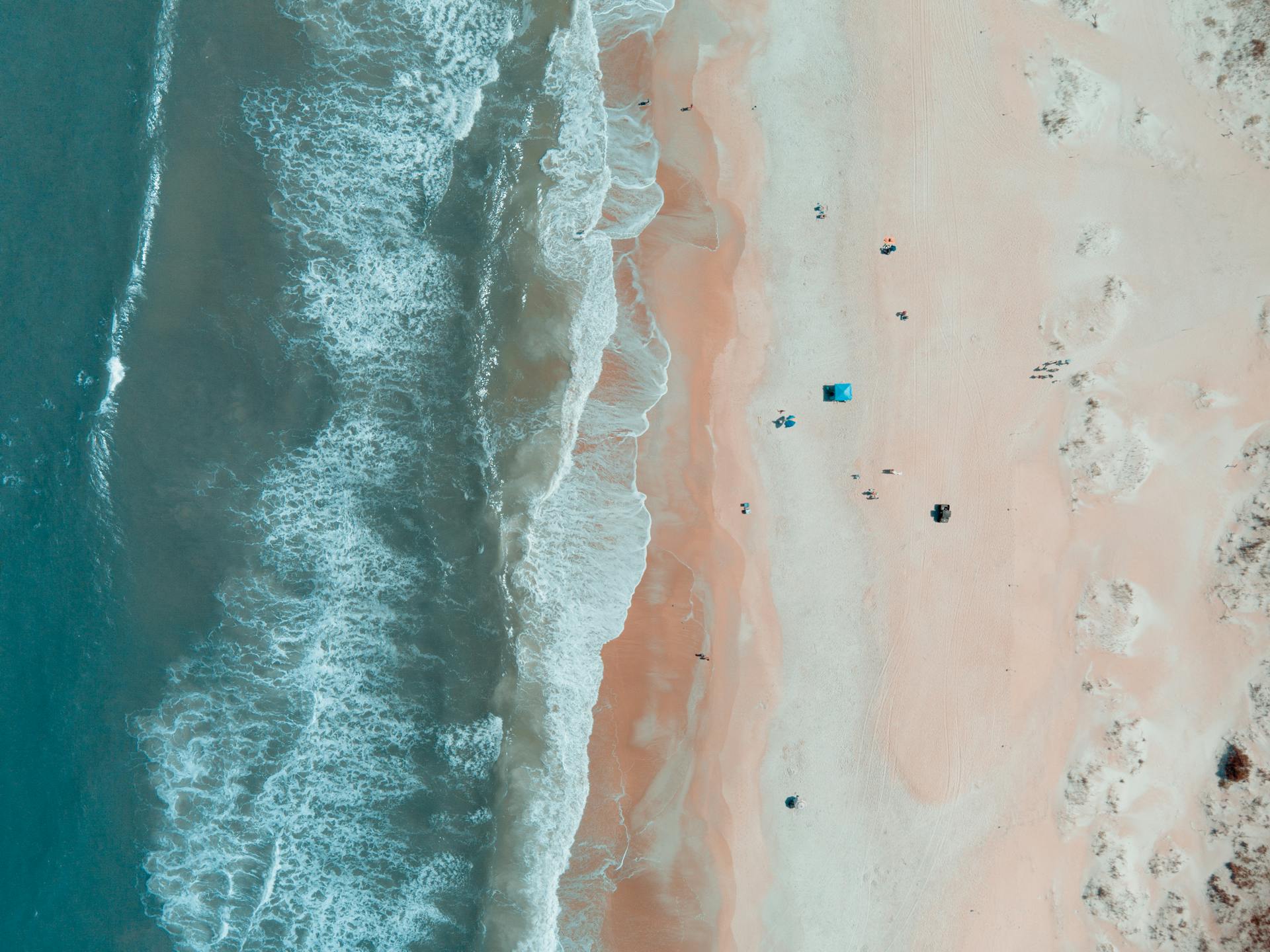 Drone shot capturing the serene shoreline and waves of St. Augustine Beach, Florida.