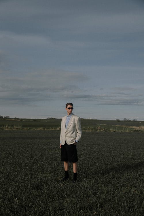 Free Man in White Dress Shirt Standing on Green Grass Field Stock Photo