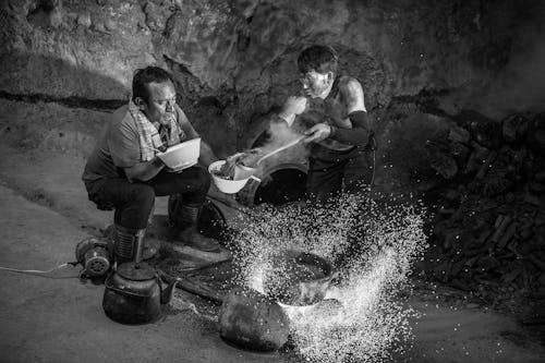 Men Serving Food in a Cave