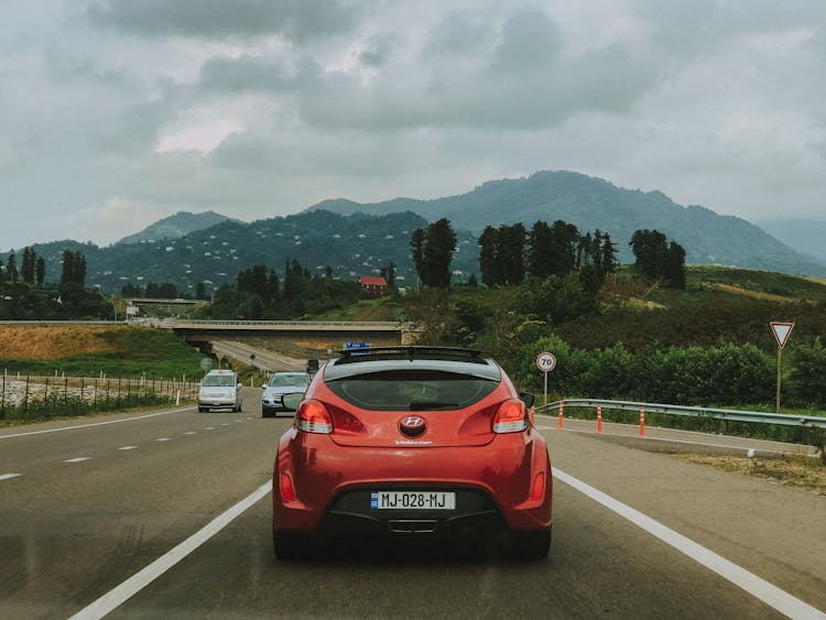 Red Car Driving Down The Highway