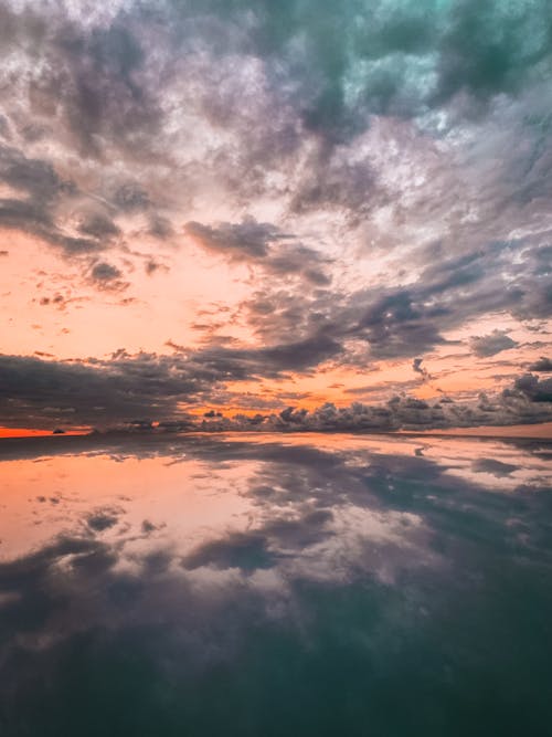Lake Reflecting Cloudy Sky At Sunset