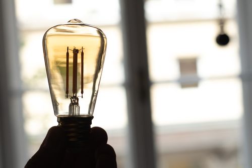 Free men holding a lightbulb in hands, creative ideas coming Stock Photo