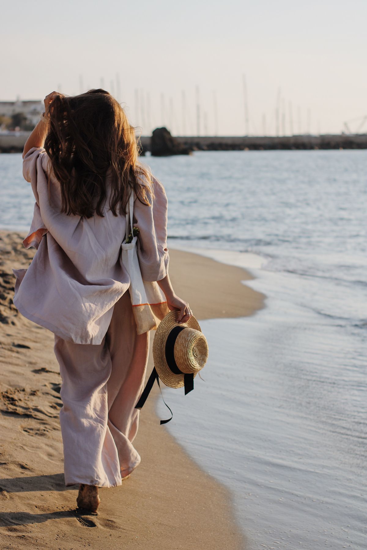 A woman walking on the shore — the easy, water-bound rhythm of a European summer