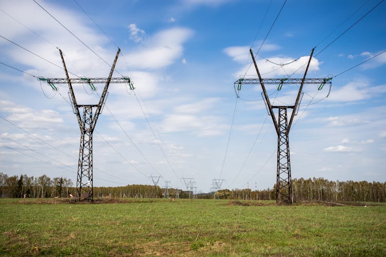 Electric Towers On Green Grass Field