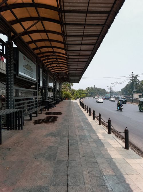 Free Quiet roadside view of a covered sidewalk in Dhaka, highlighting urban architecture and street activity. Stock Photo