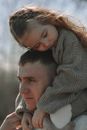 Little Girl Sitting on Her Dads Shoulders and Hugging Him