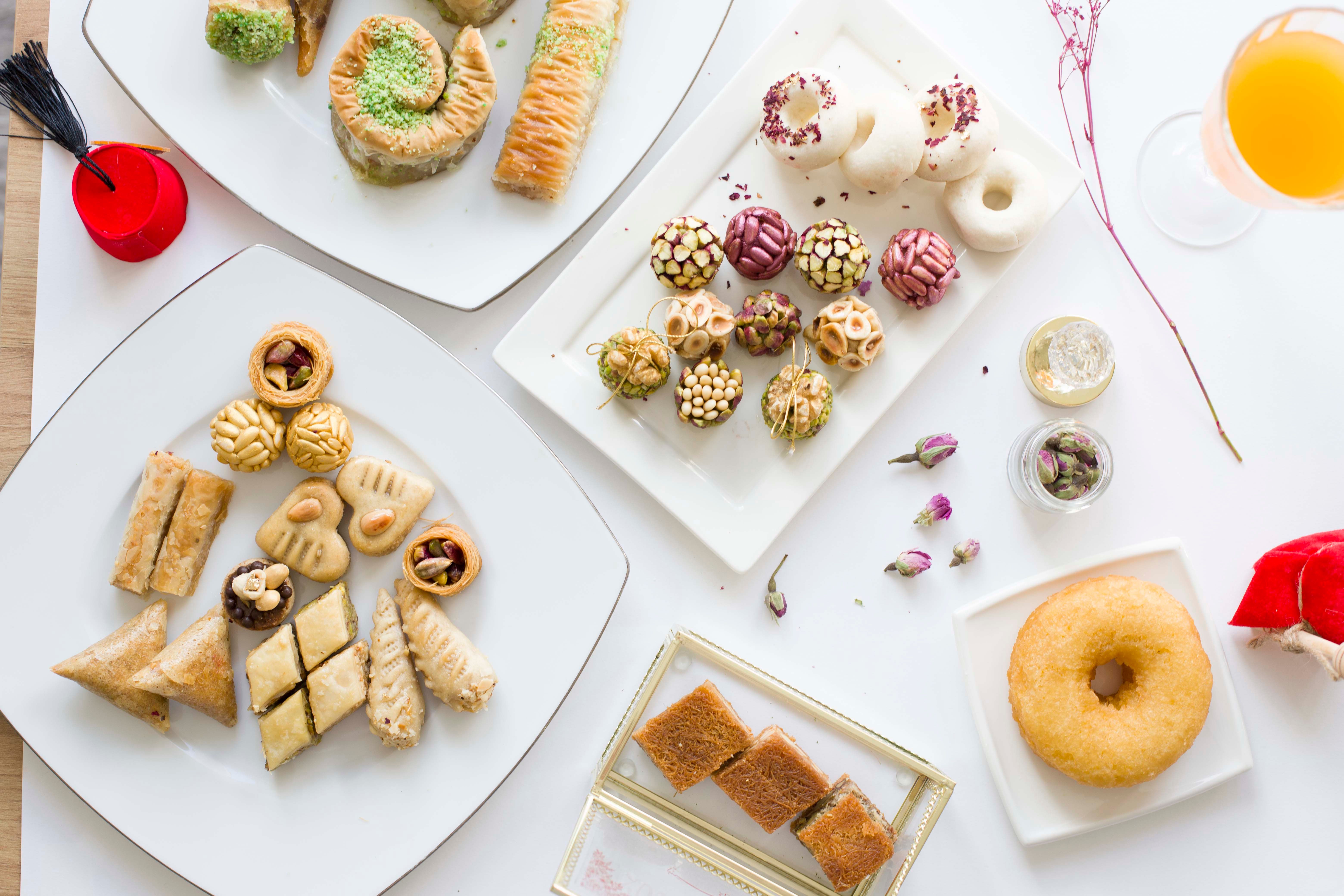 A variety of delicious pastries and sweets displayed elegantly on white plates.