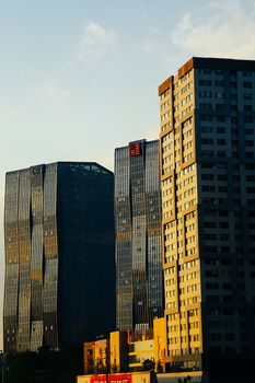 High-rise buildings illuminated by the setting sun, captured in an urban setting.