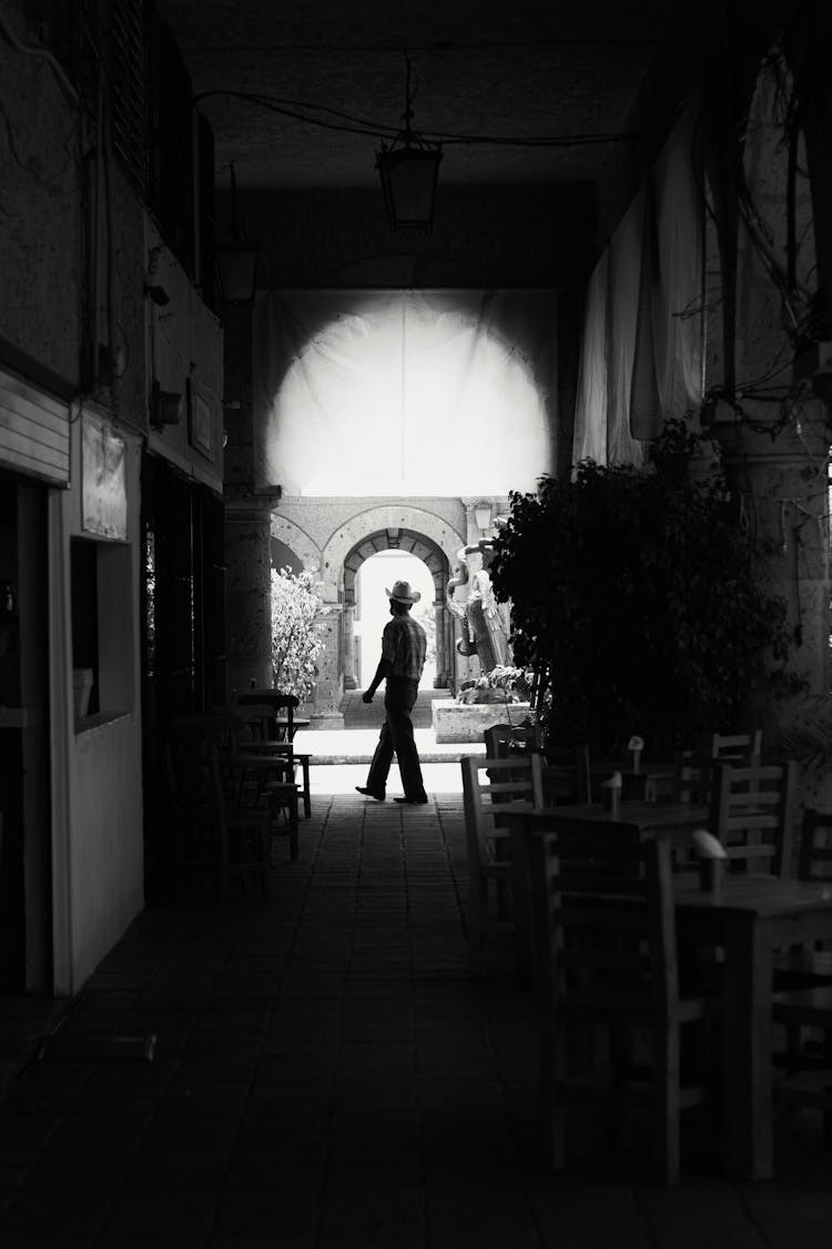 Man Walking Pass A Street Cafe 