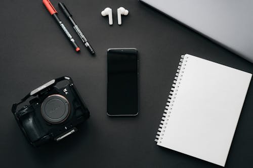 Free A Smartphone Beside the White Notebook Stock Photo